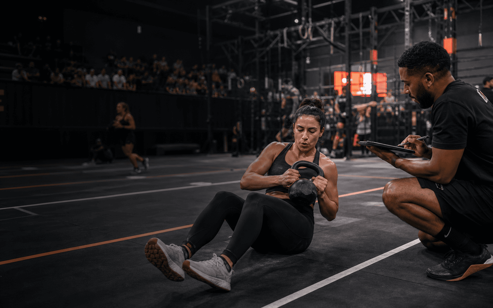 An athlete competing in a marked event lane while a judge records the score